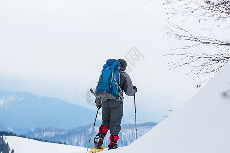 老年人登山冬天山上的徒步旅行者背景