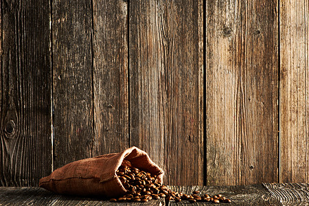 木制桌子上的麻袋里的咖啡豆图片