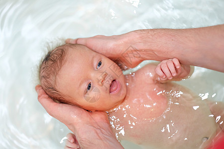 新生儿父亲的帮助下浴缸里游泳图片