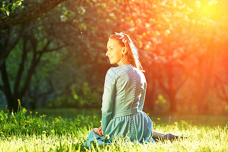 苹果花中位穿着连衣裙的漂亮女人的户外肖像图片