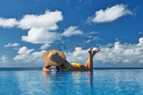 戴帽子的女人游泳池里放松图片