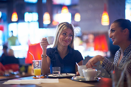 快乐的女孩朋友现代城市餐厅喝咖啡图片