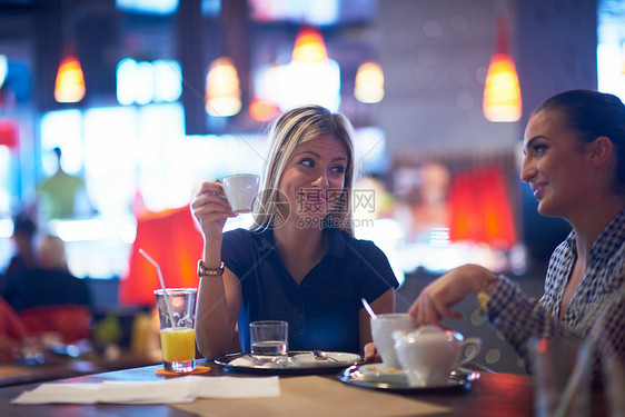 快乐的女孩朋友现代城市餐厅喝咖啡图片
