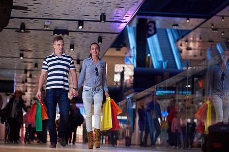 轻的夫妇现代购物中心带着购物袋图片