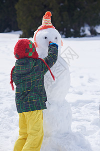 小男孩堆雪人图片