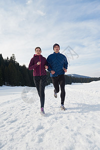 健康的轻夫妇森林里的雪地上慢跑运动员阳光明媚的冬日跑步图片