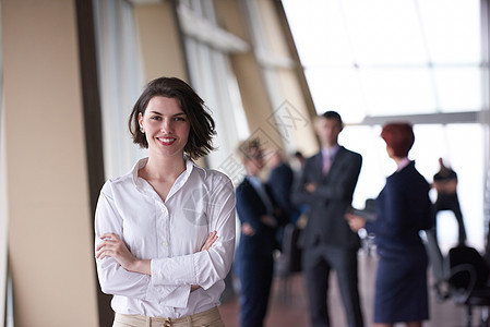 她的队前拍打轻的商业妇女的背景下闪闪发光群轻的商人现代明亮的启动办公室内部图片