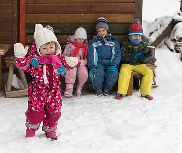孩子们的集体肖像,孩子们美丽的冬日新鲜的雪坐木屋前度假图片