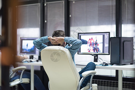 创意工人,照片编辑他的台式电脑小型启动办公室的平板电脑上工作背景