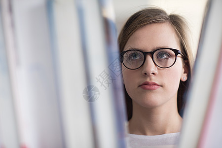 拼贴学校图书馆,选择书书架上阅读的聪明的家庭学生女孩的肖像图片