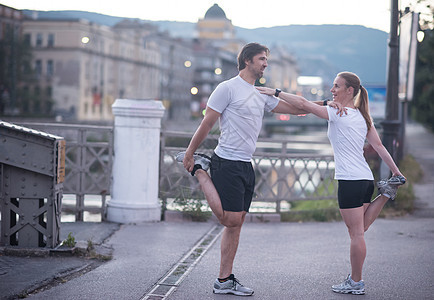 慢跑夫妇城市跑步前热身伸展图片