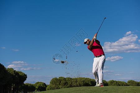 高尔夫球手击球与司机球场上美丽的晴天图片