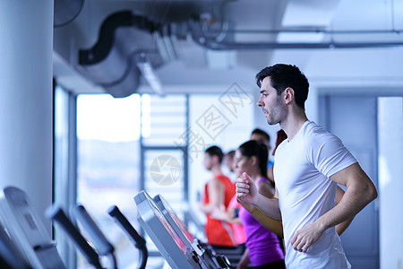 跑步男群轻人现代体育健身房的跑步机上跑步背景