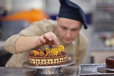 个集中的男糕点厨师厨房装饰甜点蛋糕食品的特写图片