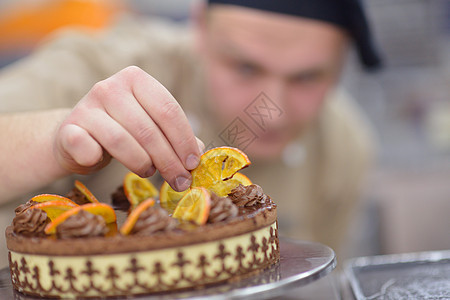个集中的男糕点厨师厨房装饰甜点蛋糕食品的特写图片