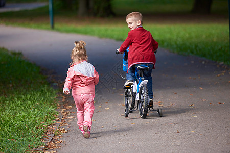 快乐的孩子公园,男孩女孩大自然与自行车玩得开心图片