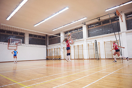 排球运动与群轻漂亮的女孩室内运动竞技场球网背景图片