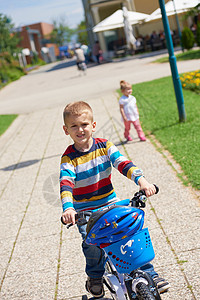 快乐的小男孩公园玩得开心,学会骑他的辆自行车图片