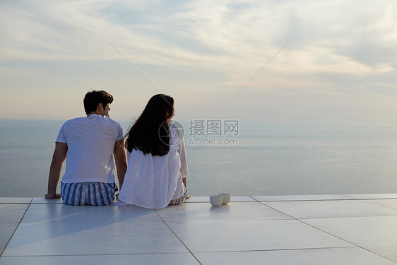 快乐的轻浪漫夫妇现代家庭户外露台上享受快乐的放松微笑图片