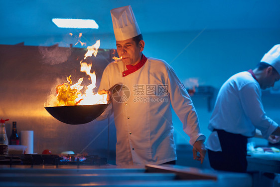 酒店厨房的厨师用火准备蔬菜食品图片