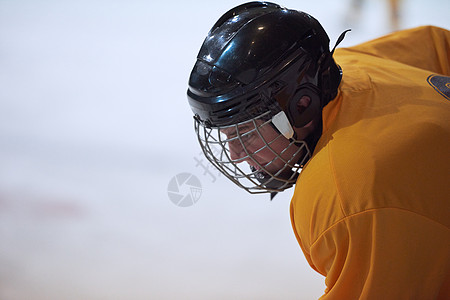 轻冰球运动员黑色背景下训练的肖像图片