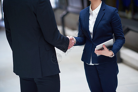 与企业的伙伴关系理念,男女握手,并现代办公室内部达成协议图片
