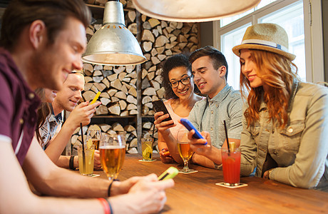 人,休闲,友谊,技术沟通的群快乐的微笑朋友酒吧酒吧用智能手机饮料图片