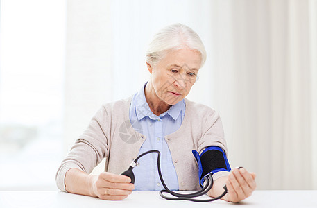 医学,龄,保健人的老妇女用血压计检查血压水平家里图片