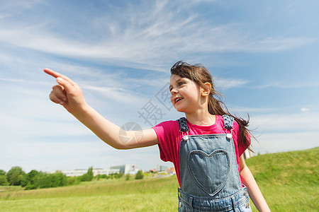 夏天,童,休闲,方向人的快乐的小女孩指着绿色的夏天田野图片