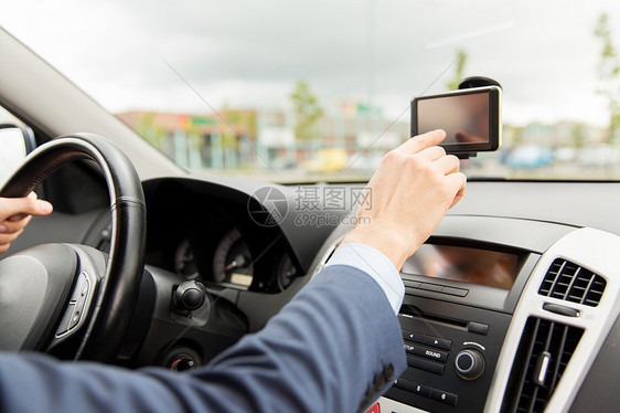 运输,商务旅行,技术,导航人的男手用GPS导航器,同时驾驶汽车图片