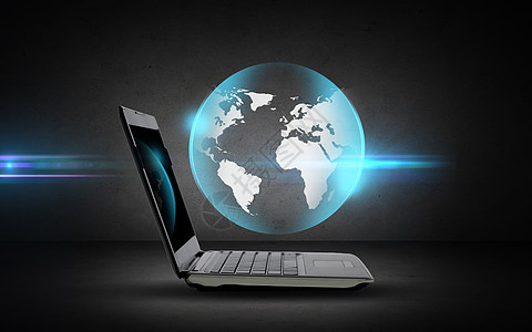 技术,商业,大众媒体互联网开放式笔记本电脑与地球投影深灰色背景图片
