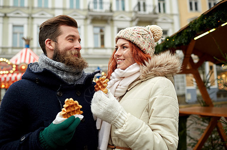 节日,冬天,诞节人们的幸福的夫妇穿着温暖的衣服走老城图片