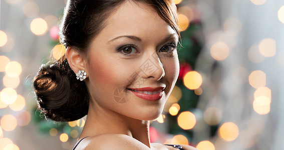 人,假日,珠宝豪华微笑的女人脸与钻石耳环诞灯背景图片