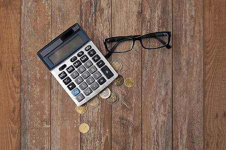 商务,金融,货币簿记计算器,眼镜欧元硬币木制桌子背景图片