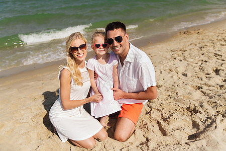 家庭,假期,收养人的快乐的男人,女人小女孩戴着太阳镜夏天的海滩图片