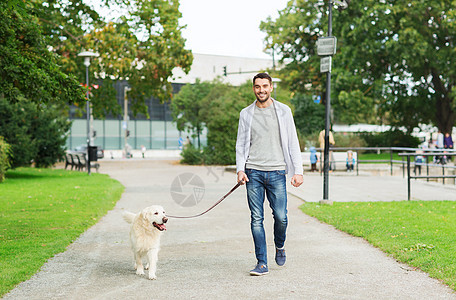 家庭,宠物,动物人的快乐的人与拉布拉多猎犬城市公园散步图片