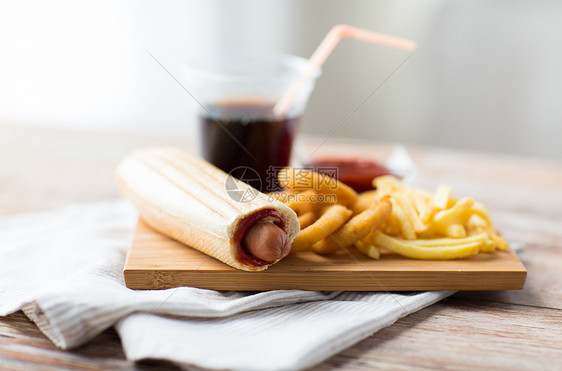 快餐健康的饮食油炸鱿鱼圈,炸薯条,饮料番茄酱木桌上图片