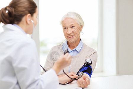 医学,龄,保健人的医生与血压计检查快乐老妇女的血压水平医院图片