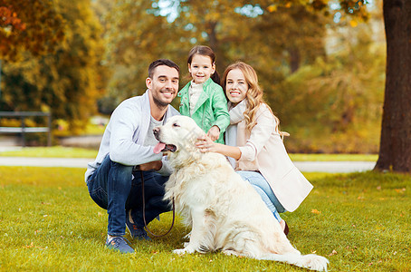 家庭,宠物,家畜,季节人的快乐的家庭与拉布拉多猎犬秋天公园散步图片