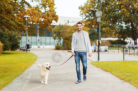 家庭,宠物,家畜,季节人的快乐的人与拉布拉多猎犬秋季城市公园散步图片