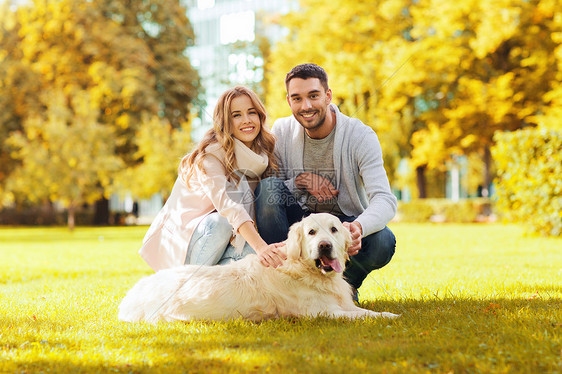 家庭,宠物,家畜,季节人的快乐的夫妇与拉布拉多猎犬秋季城市公园散步图片