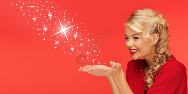 人们,节日,诞节,魔法冬天的可爱的女人穿着红色的衣服,她的手掌上发送星星红色的背景图片