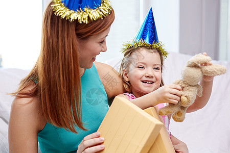假期,生日,家庭,童人的快乐的母亲小女孩戴着派帽,家里礼品盒玩具图片
