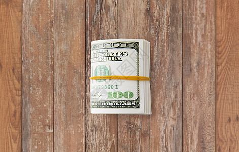 商业金融投资储蓄腐败木桌上绑着橡胶的美元木桌上图片
