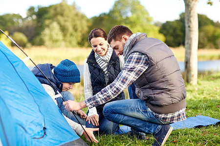 野营,旅游,远足,家庭人的快乐的父母儿子户外搭帐篷图片