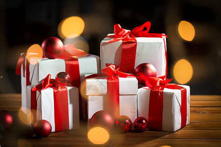 诞节,假日,礼物,新庆祝礼品盒红球木地板上的灯光背景图片