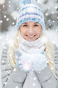 季节,诞节人们的快乐的微笑轻女人冬天的森林里捧着雪图片