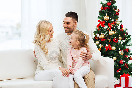 家庭,诞节,假日人的快乐的母亲,父亲小女儿坐家里的沙发上图片