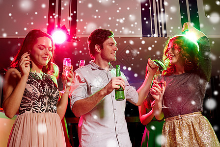新派,假期,庆祝,夜生活人们的微笑的朋友俱乐部雪的效果中碰杯含酒精的香槟啤酒图片
