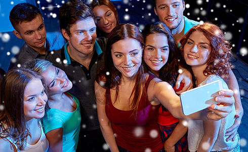 派,技术,夜生活人的微笑的朋友与智能手机自拍俱乐部雪的效果图片